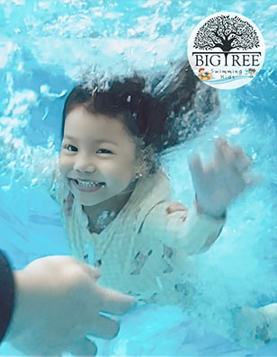 เด็กกำลังเรียนว่ายน้ำในสระน้ำอุ่นน้ำเกลือที่ Big Tree Love Kids Village ไทรม้า นนทบุรี
